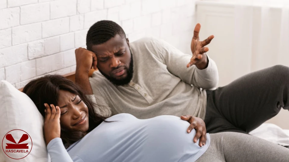 picha inaonesha mwanamke akiwa amekunja sura kuonesha kama anapata maumivu na mwanaume pembeni akiwa katika mshangao.