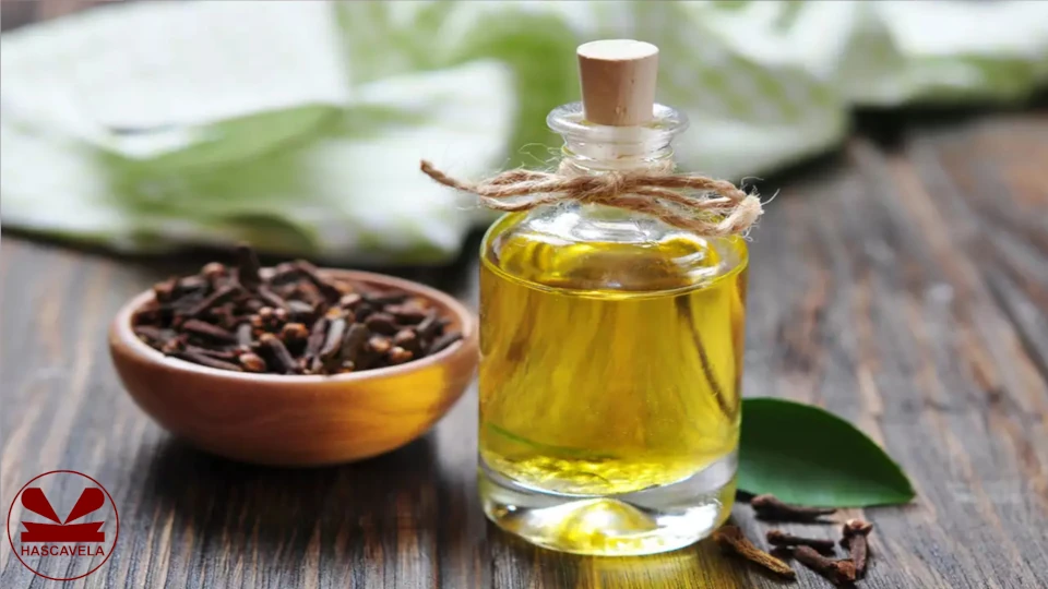 Pichani kuna kichupa kidogo chenye mafuta ya karafuu na pembeni kuna kibakuli kidogo cha mbao chenye karafuu.