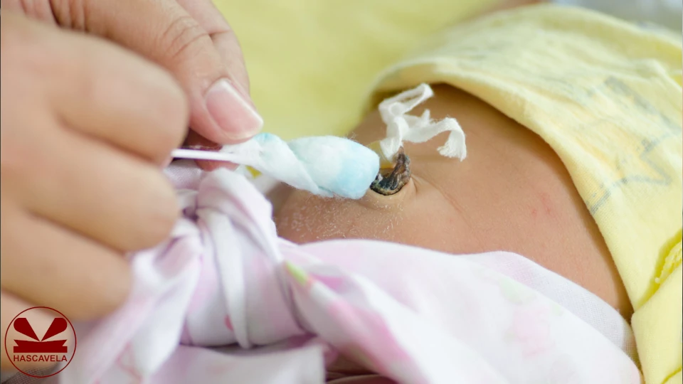 Kwenye picha imeonesha mtoto mchanga akiwa amelala na amefunuliwa sehemu ya kitovu chake, na kuna mkono ulioshikilia pamba ukijaribu kusafisha kitovu cha mtoto.