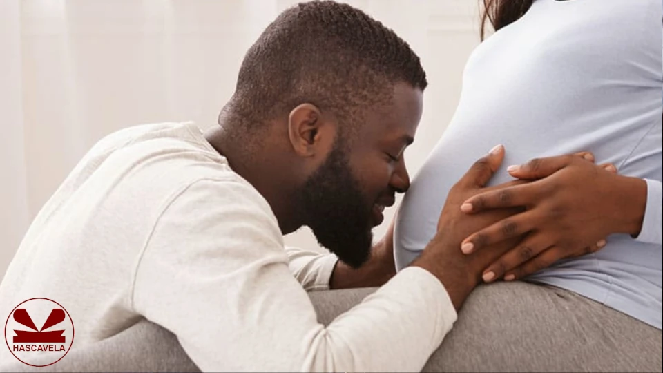 Pichani anaonekana mwanaume akiwaa amechuchumaa huku kichwa chake akiwa amekisogeza karibu na tumbo la mke wake ambaye ni mjamzito.