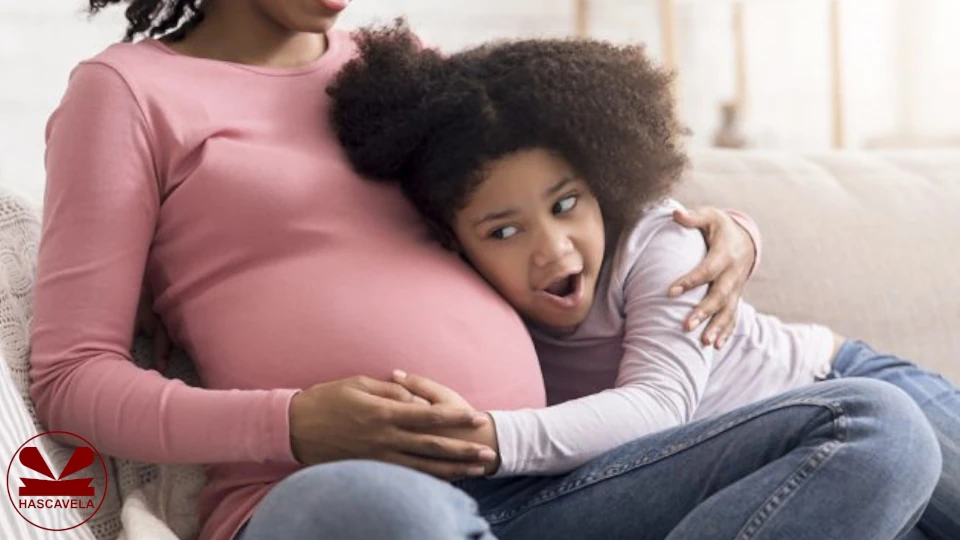 Pichani anaonekana mama na mtoto wake mkubwa wa kike ambaye ameengamisha kicha chake kwenye tumbo la mama yake ambaye ni mjamzito.