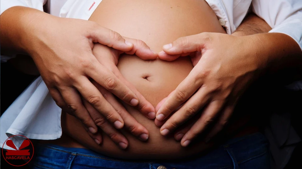 Pichani wanaonekana mwanamke na mwanaume wakiwa wamesimama na mwanaume akiwa nyuma ya mwanamke na wote washikilia kwa mikono yao yoye tumbo la mwanamke ambaye ni mjamzito.