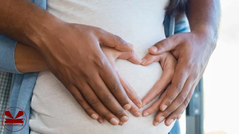 Pichani wanaonekana mwanamke na mwanaume wakiwa wamesimama na mwanaume akiwa nyuma ya mwanamke na wote washikilia kwa mikono yao yoye tumbo la mwanamke ambaye ni mjamzito.