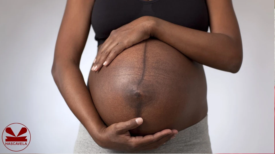 Pichani kuna mwanamke mjamzito akiwa amezungusha mikono yake yote miwili tumboni kwake, pia tumbo lake lina mstari mweusi uliokolea katikati ya tumbo lake.