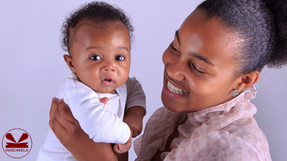 picha inamuonesha mama akiwa amembeba mtoto na akiwa kwenye tabasamu kuonesha kumfurahia
