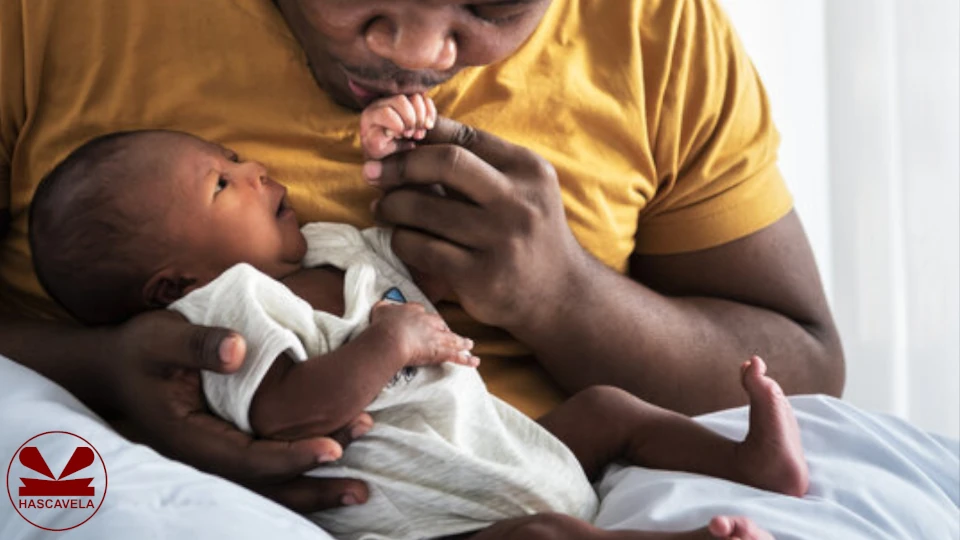 picha hii imeonesha baba akiwa amembeba mikononi mtoto wake mchanga mwenye umri wa mwezi mmoja